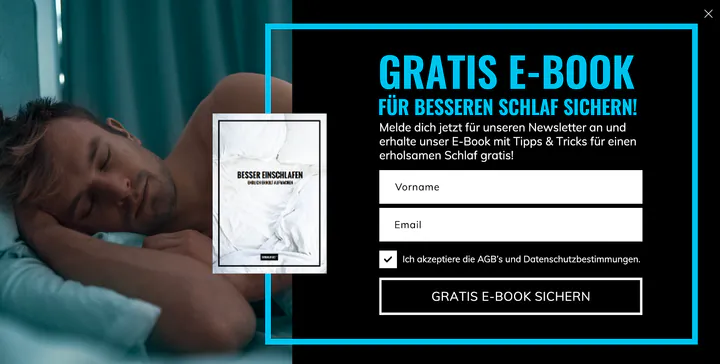 BrainEffect pop-up in German: a man asleep on a pillow beside the cover of a sleep e-book and the bright blue headline “Gratis E-Book für besseren Schlaf sichern!”, with name and email fields.
