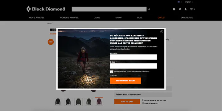 Black Diamond product page dimmed behind a wide sign-up pop-up. On the left, a hiker wearing a headlamp walks over rocky ground at dusk; on the right, white capitals ask whether you want to be first to hear about exclusive offers, competitions and travel stories, above fields for first name and email, a consent checkbox, and an orange “Informiert mich!” button.